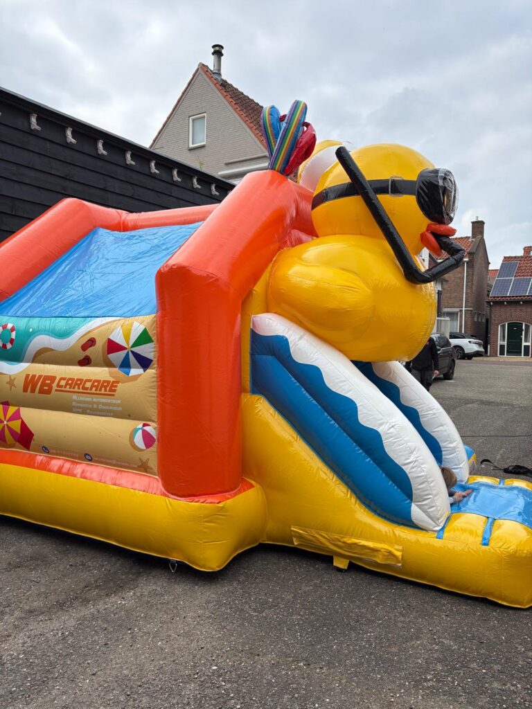 De badeend springkussen opgesteld op het gras met valmatten eromheen